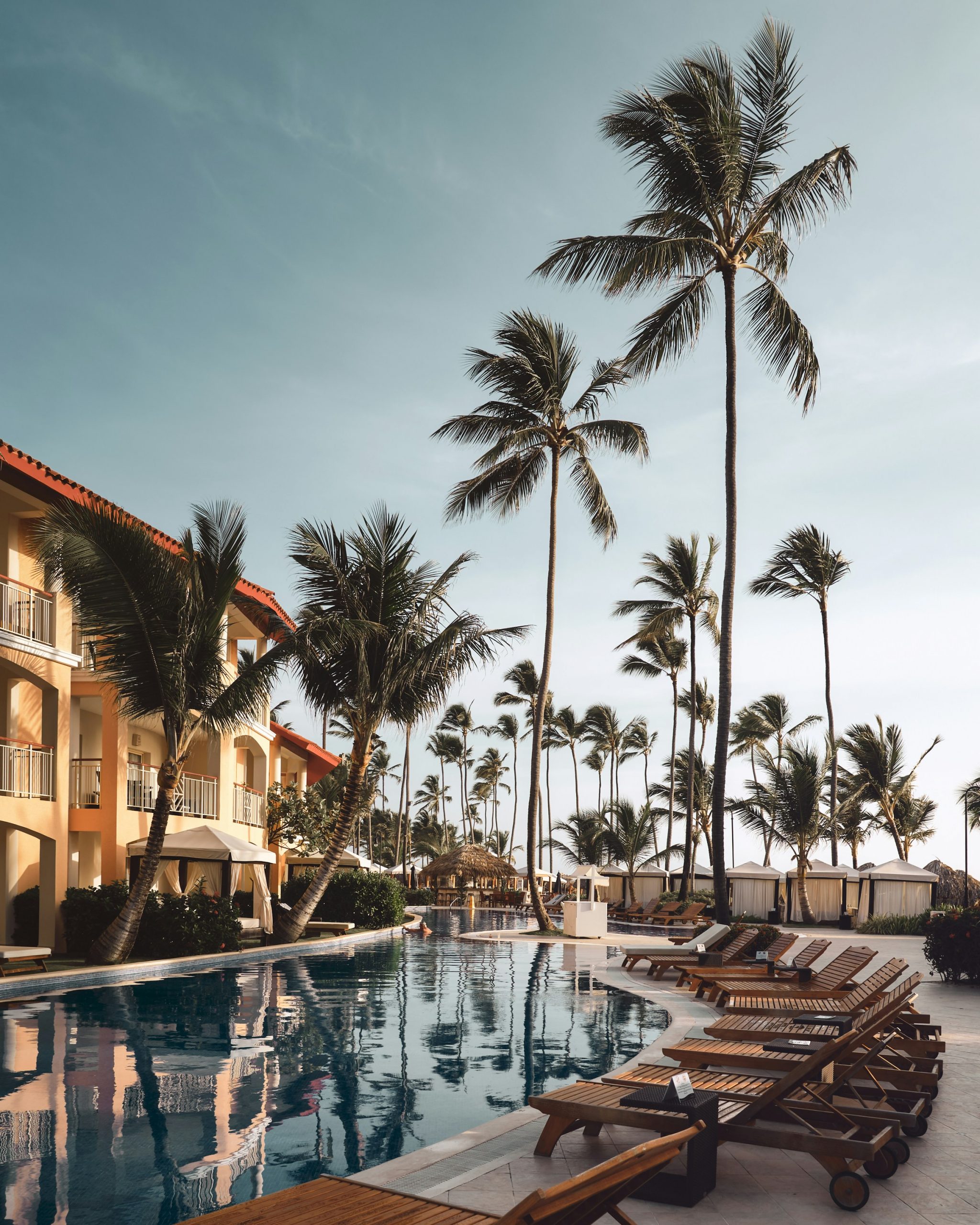 Luxury resort pool with palm trees at golden hour