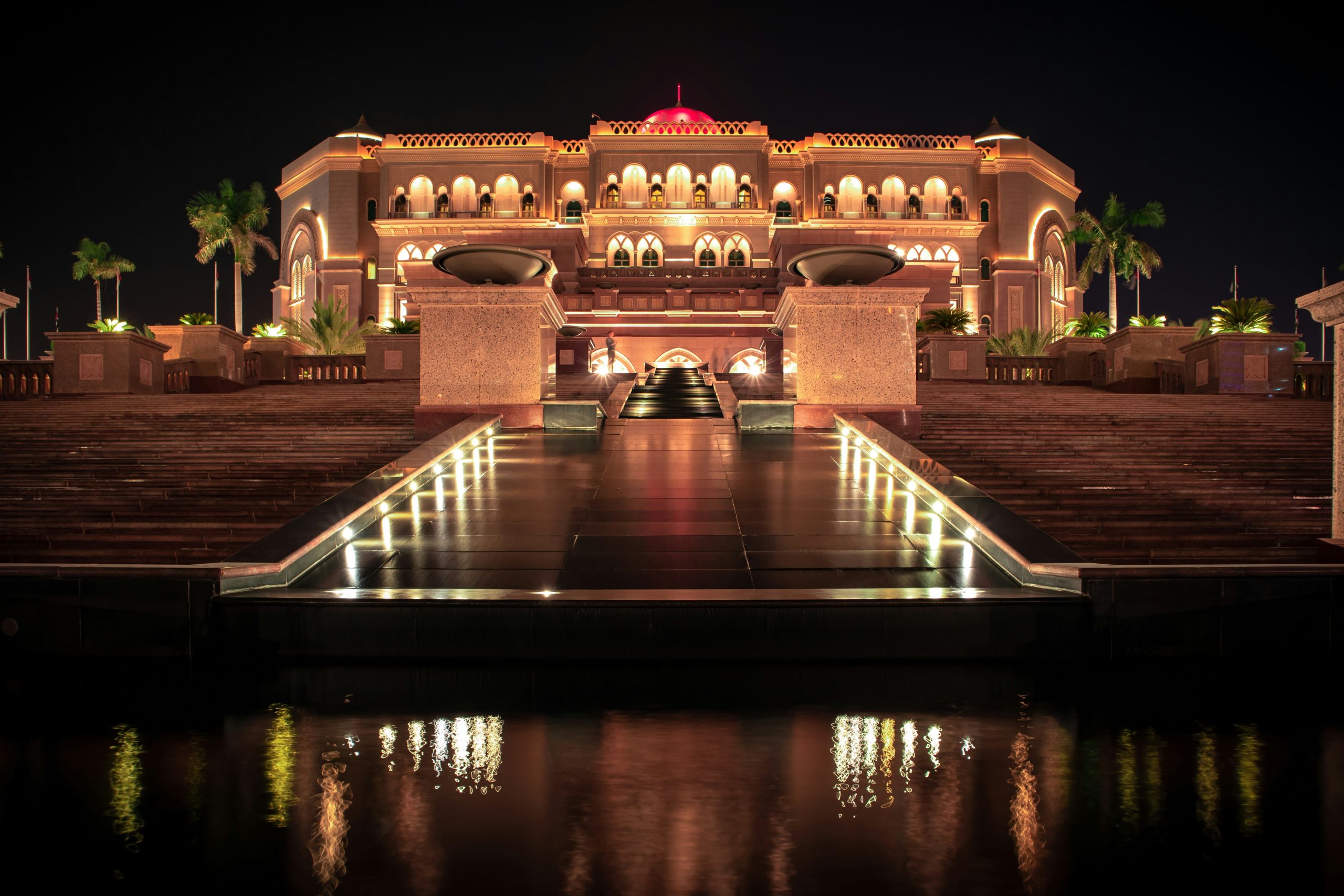 Emirates Palace Mandarin Oriental illuminated at night, the grand stepped water approach leading to the central dome, Abu Dhabi, UAE
